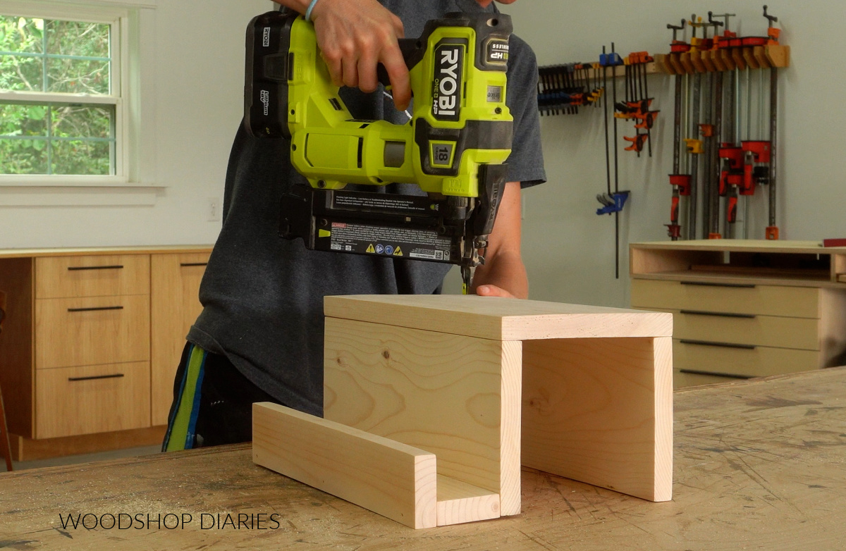 Shara Woodshop Diaries assembling sofa arm tray with brad nails on workbench