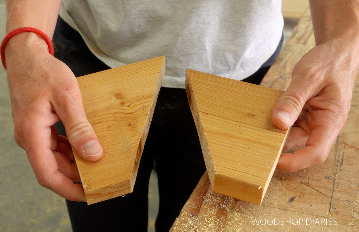 Shara Woodshop Diaries holding two identical side pieces of 1x6 cut for DIY shoe rack assembly