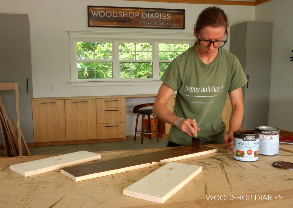 Shara Woodshop Diaries staining 1x6 boards on workbench in workshop