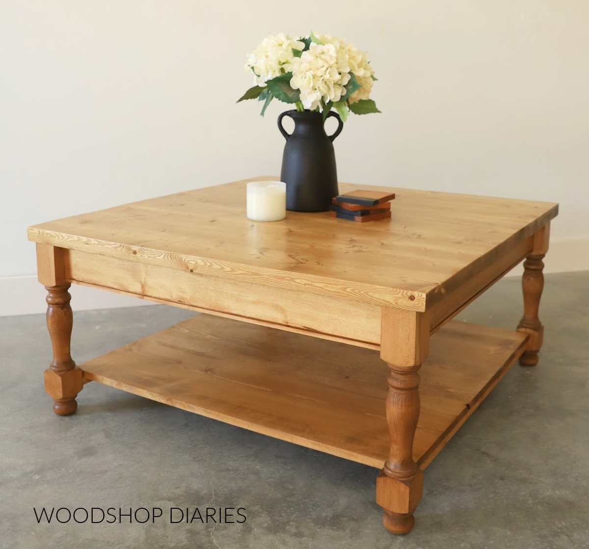 Completed DIY square coffee table stained medium brown with vase on top