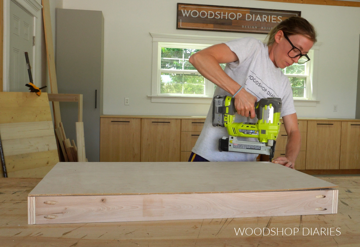 Shara Woodshop Diaries stapling plywood bottom onto drawer box