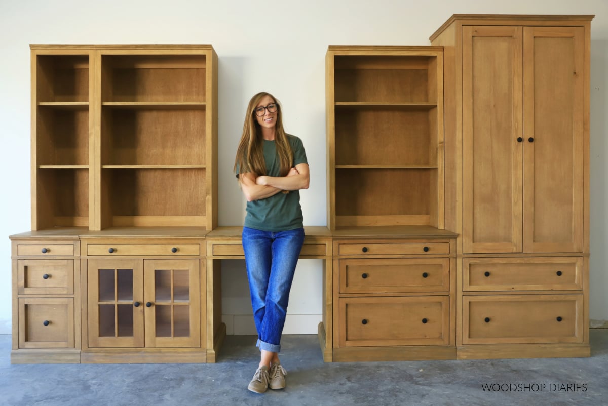 Shara Woodshop Diaries standing in front of modular furniture system with base cabinets, upper hutch cabinets, and armoire