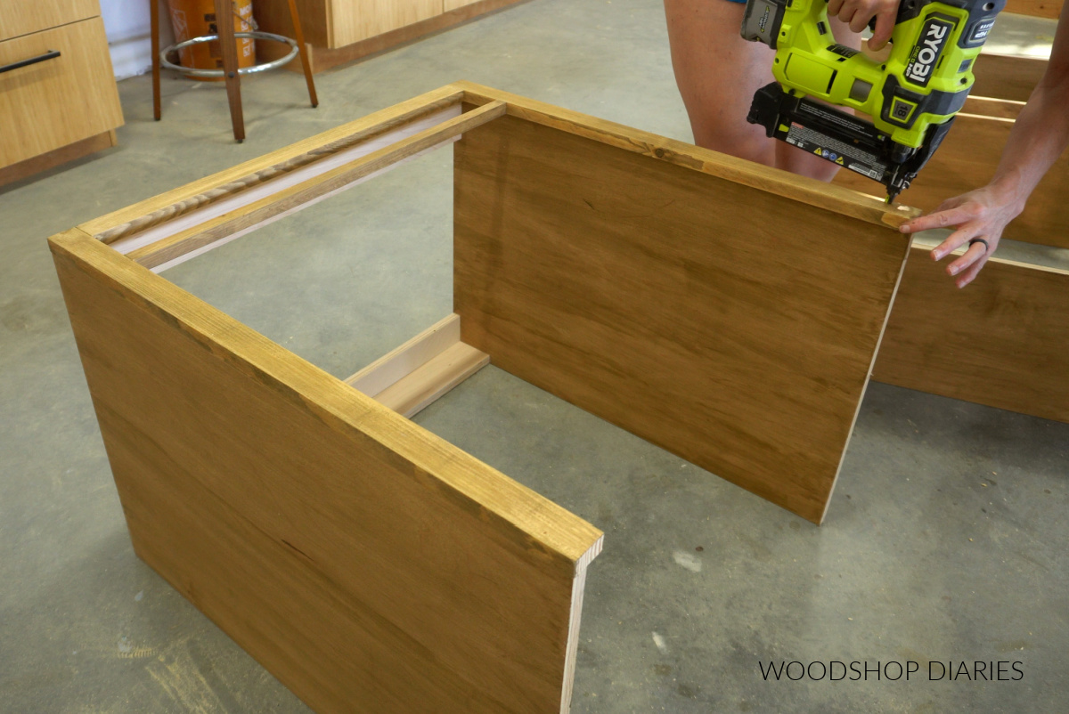 Shara Woodshop Diaries nailing face frame onto front of DIY desk cabinet