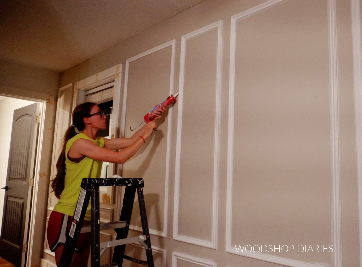 Shara Woodshop Diaries caulking picture frame molding installed on wall