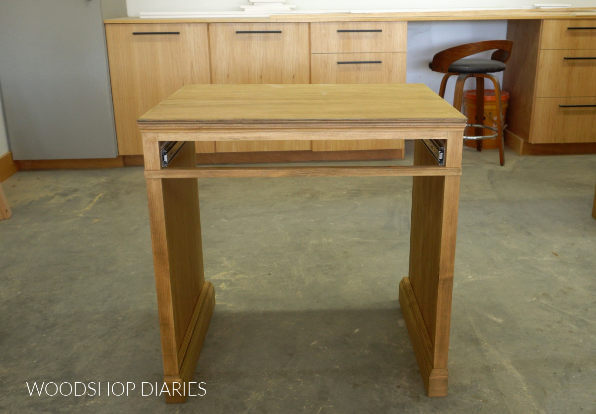 Modular writing desk cabinet with trim detail installed in workshop