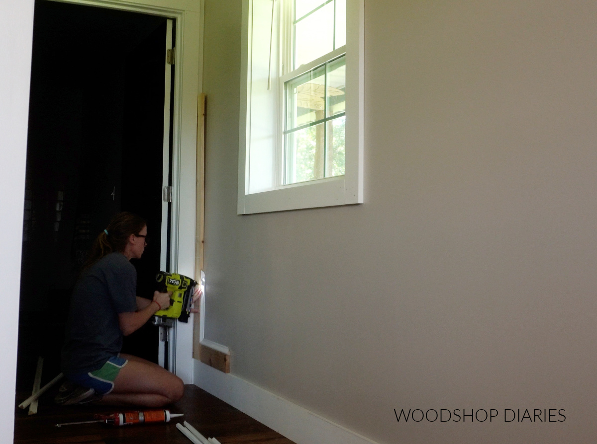 Shara Woodshop Diaries installing picture frame molding on wall using 1x4 spacer blocks