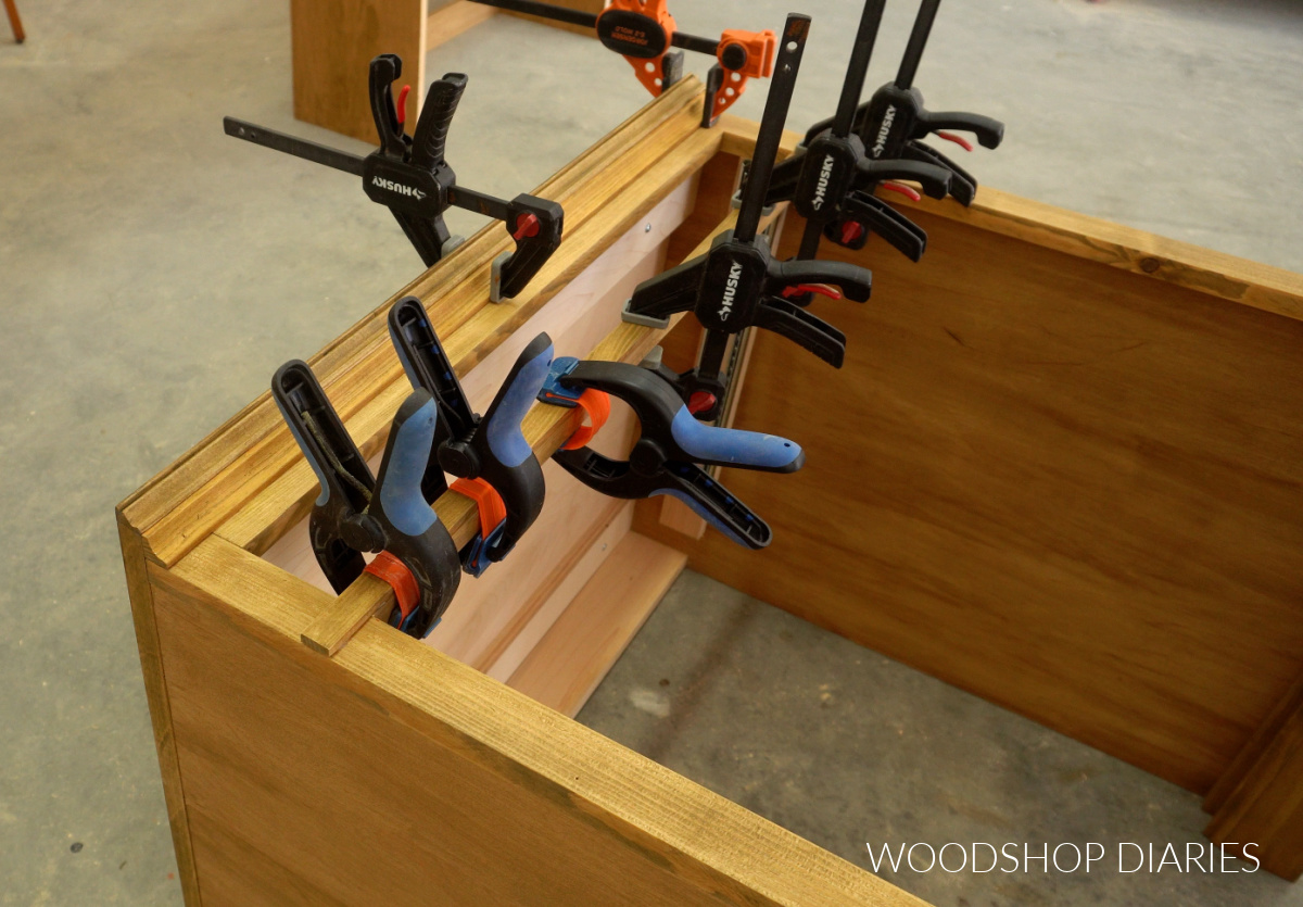 Close up of trim glued onto front of modular desk cabinet